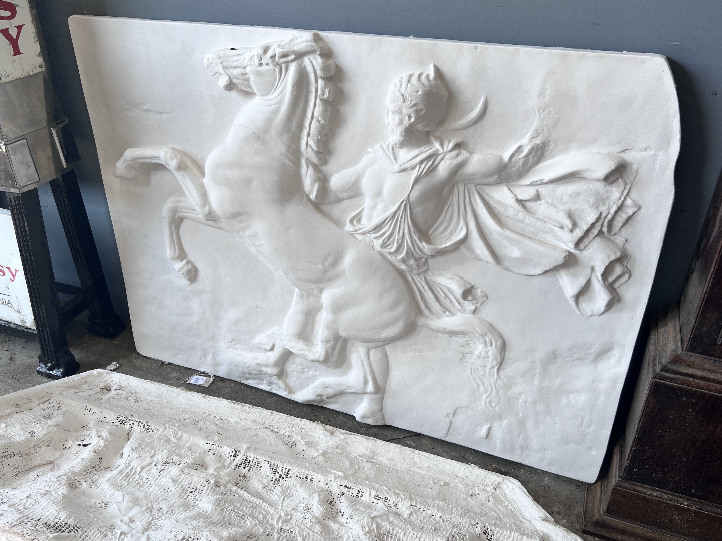 A pair of cast plaster panels of horsemen, each panel width 140cm, height 100cm